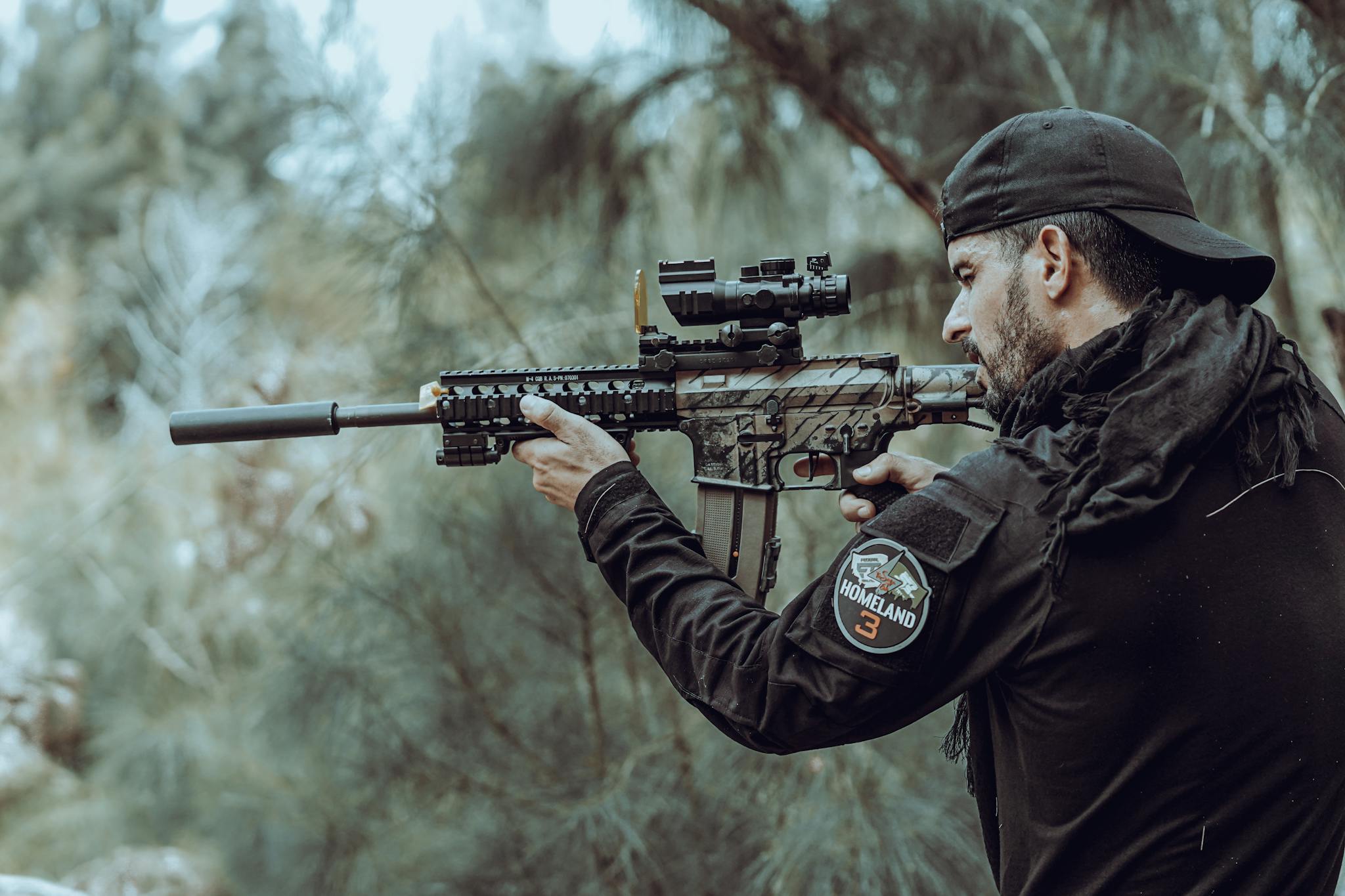 A tactical marksman aims with focus in a serene outdoor environment.